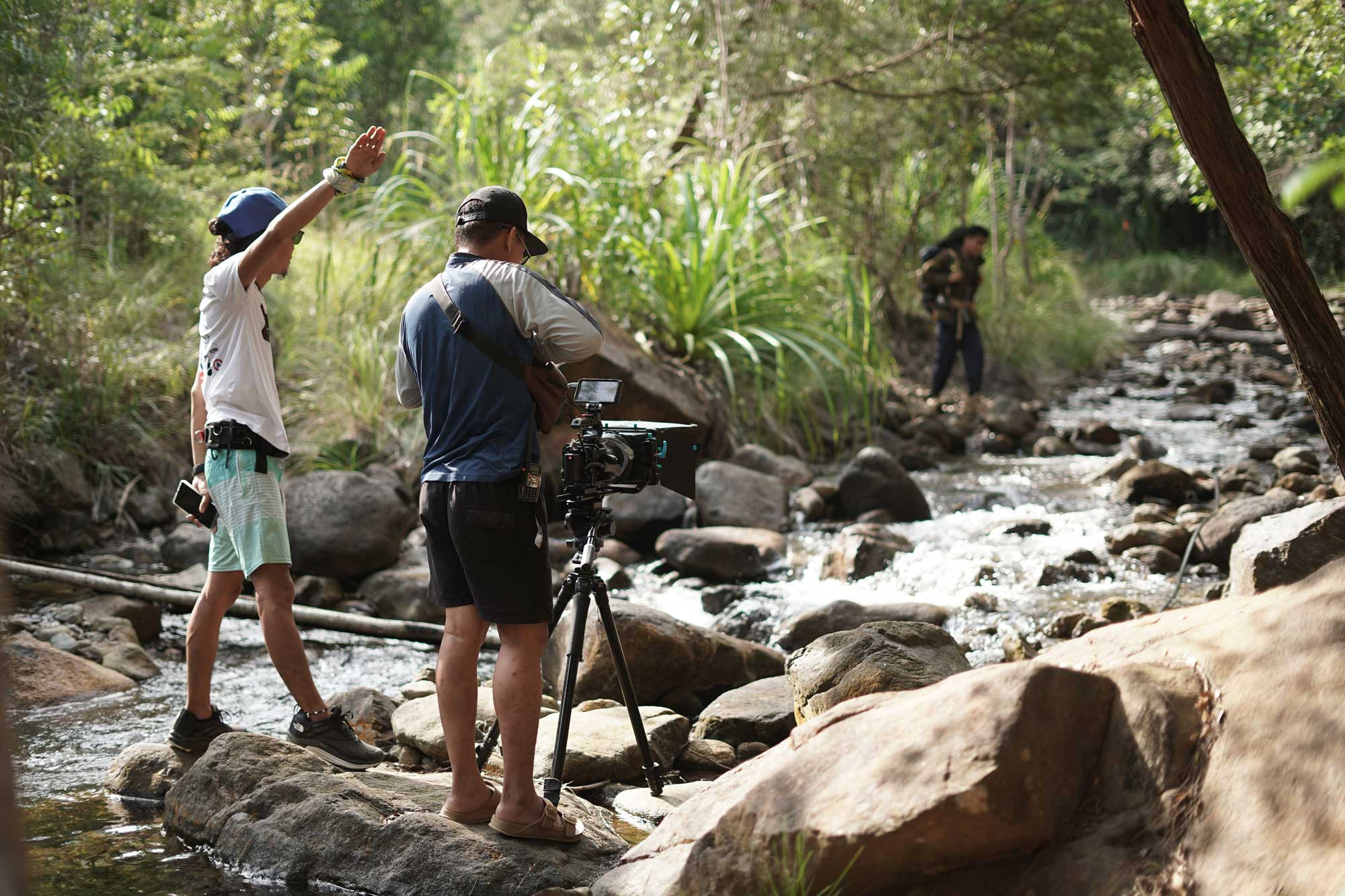 Documentary crew filming beside a forest stream